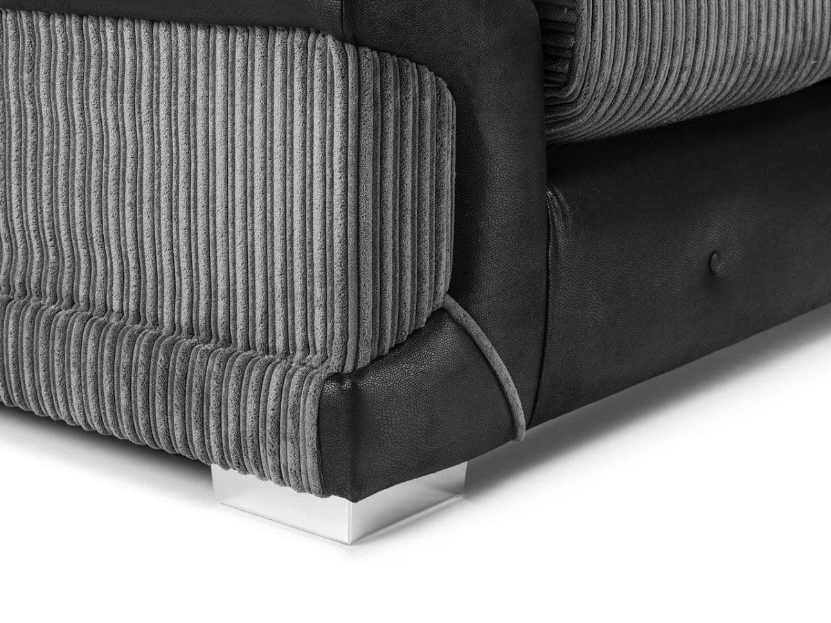 Close-up of a modern grey corduroy and black leather sofa corner with metal leg