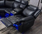 Black leather recliner corner sofa with LED lights and built-in cup holders in a modern living room.