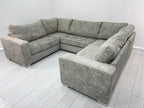 Modern grey U-shaped sofa with plush cushions in a bright room with light wood flooring