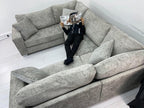 Modern U-shaped grey fabric sofa in white living room with person reading a magazine