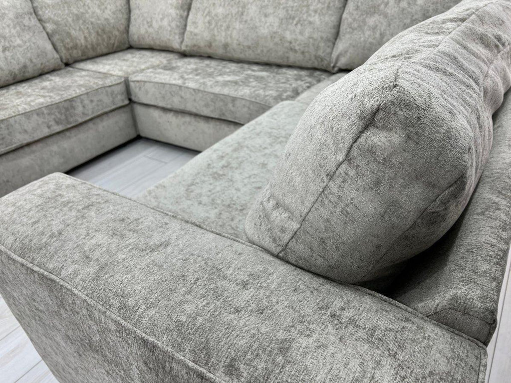 Modern U-shaped grey fabric corner sofa with plush cushions on light wood flooring