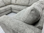 Modern U-shaped grey fabric corner sofa with plush cushions on light wood flooring