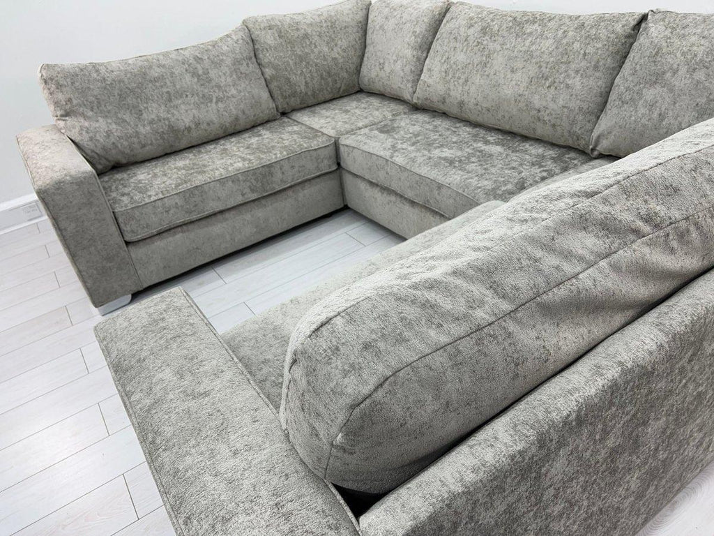 Grey U-shape sectional sofa with plush cushions on a light wood floor
