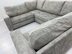 Grey U-shape sectional sofa with plush cushions on a light wood floor