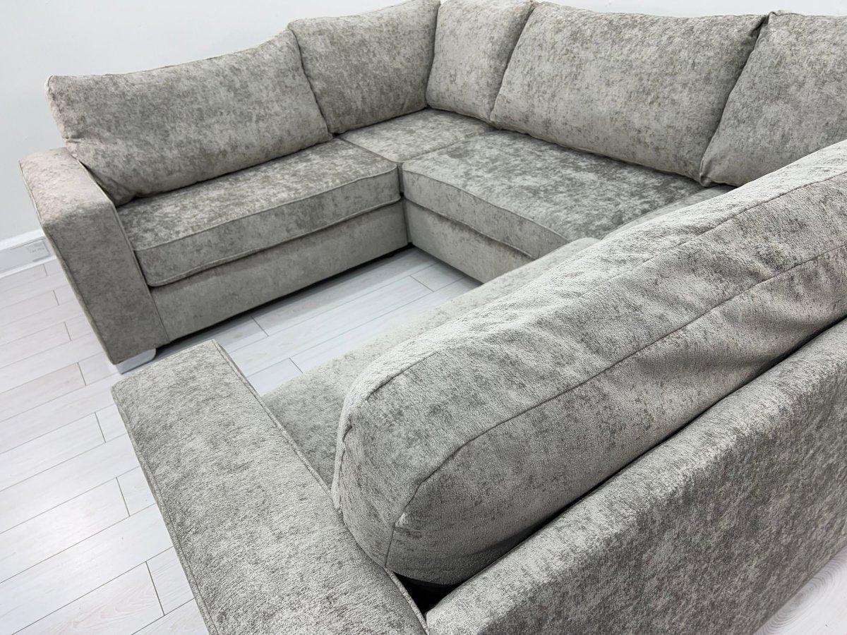 Grey U-shape sectional sofa with plush cushions on a light wood floor