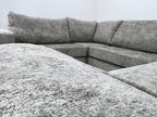 Modern U-shape grey corner sofa with plush fabric upholstery in a bright living space
