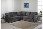 Grey corner sofa with plush cushions in a modern living room, studded detail, two side tables