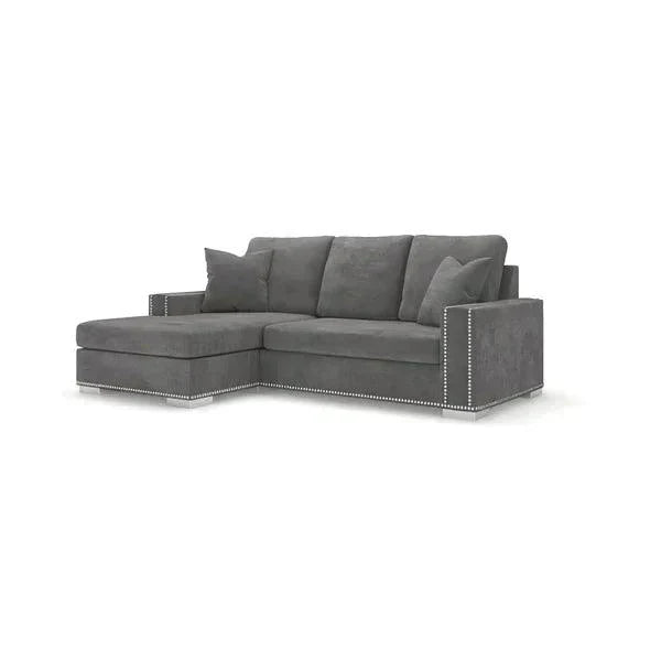 Grey right-hand small corner sofa with studded trim and plush cushions on white background