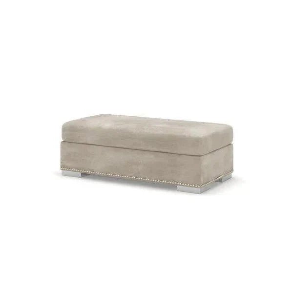 Light grey rectangular footstool with chrome legs and nailhead trim on white background