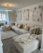 Large cream U-shaped boucle sofa in elegant living room with neutral décor and modern lighting