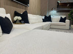 Large U-shaped cream boucle sofa with black cushions, modern living room decor