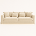 Large cream velvet sofa with deep cushions and plush pillows on a neutral background