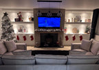 Cream U-shaped sofa in a modern living room with Christmas decor, shelves, and TV center