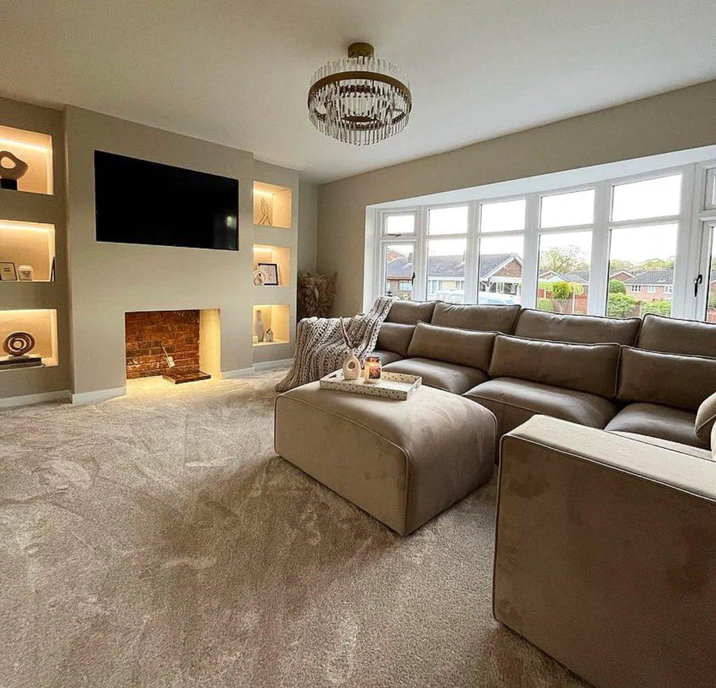 Latte modular corner sofa in a modern living room with large windows, tray decor, and neutral carpet.