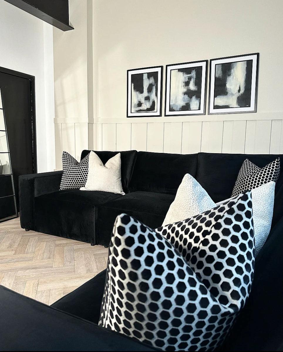 Modern black modular corner sofa with geometric throw pillows in stylish living room