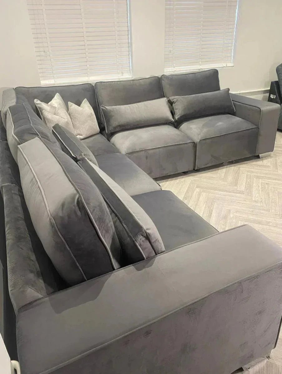 Large grey modular corner sofa with plush cushions in a modern living room setting