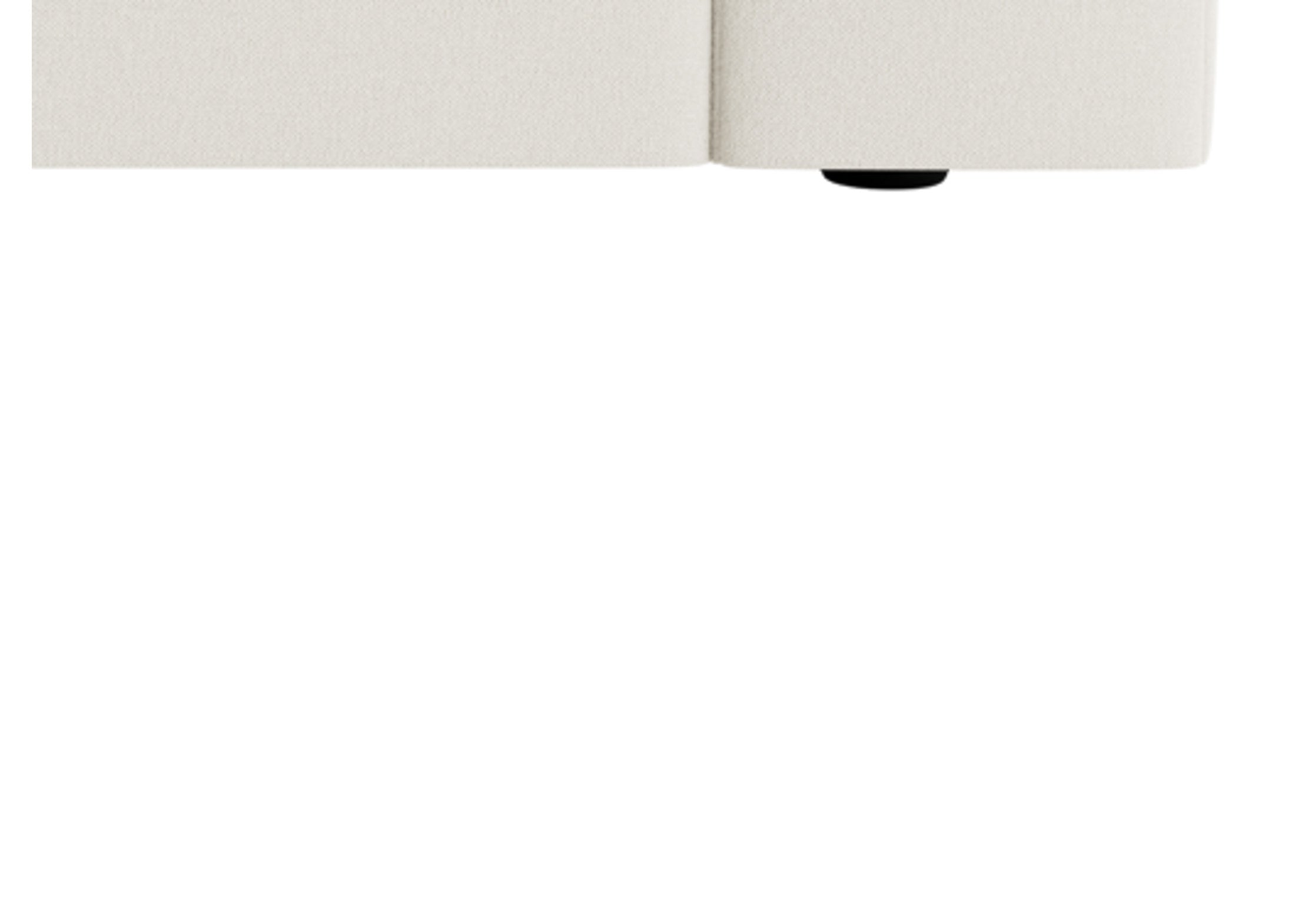 Close-up of cream modular sofa base with textured upholstery and low black feet