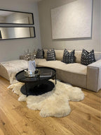Ivory cinema sofa with removable footstool, black pattern cushions, and modern decor