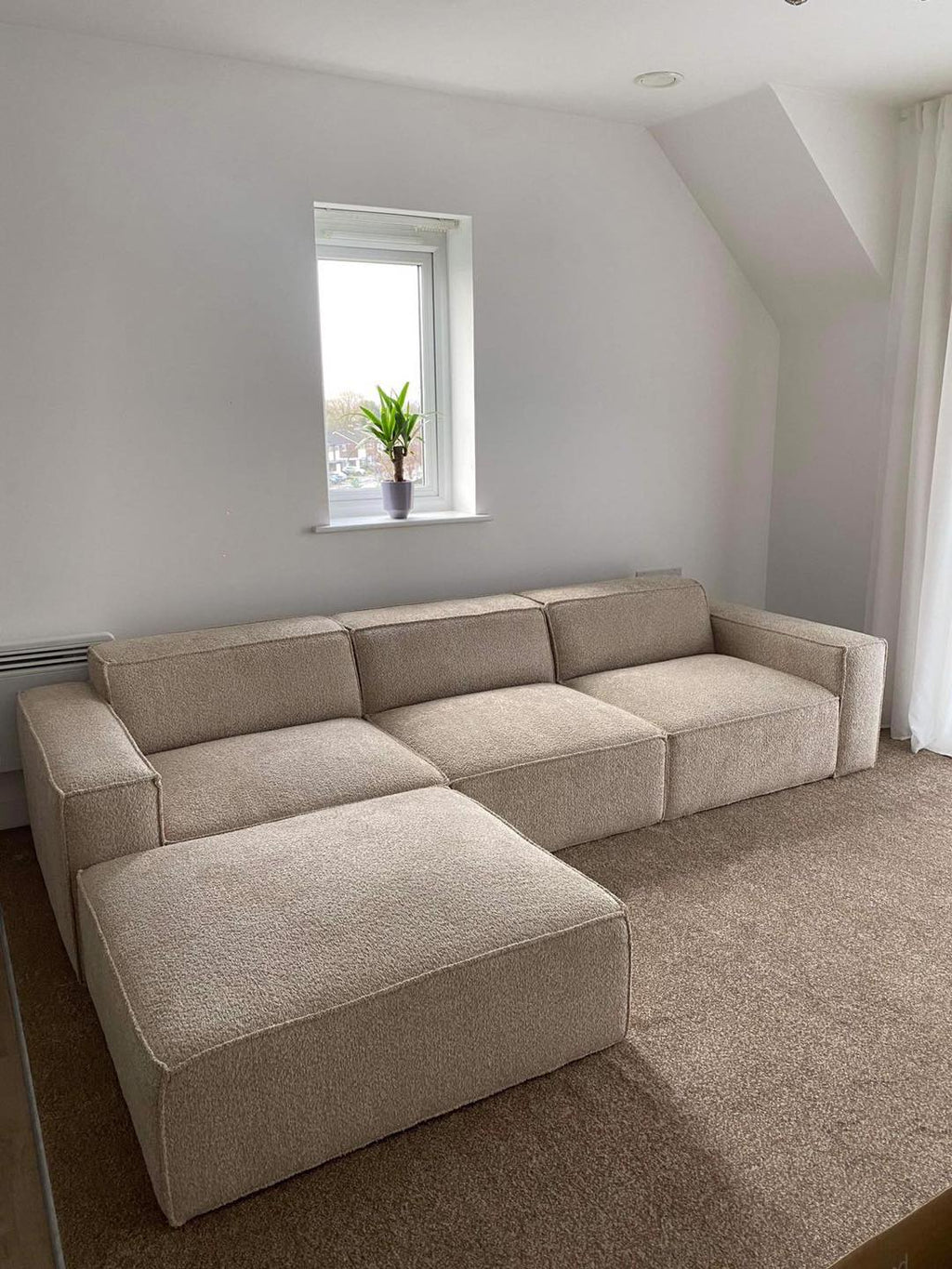 Ivory modular cinema sofa with removable footstool in bright carpeted living room