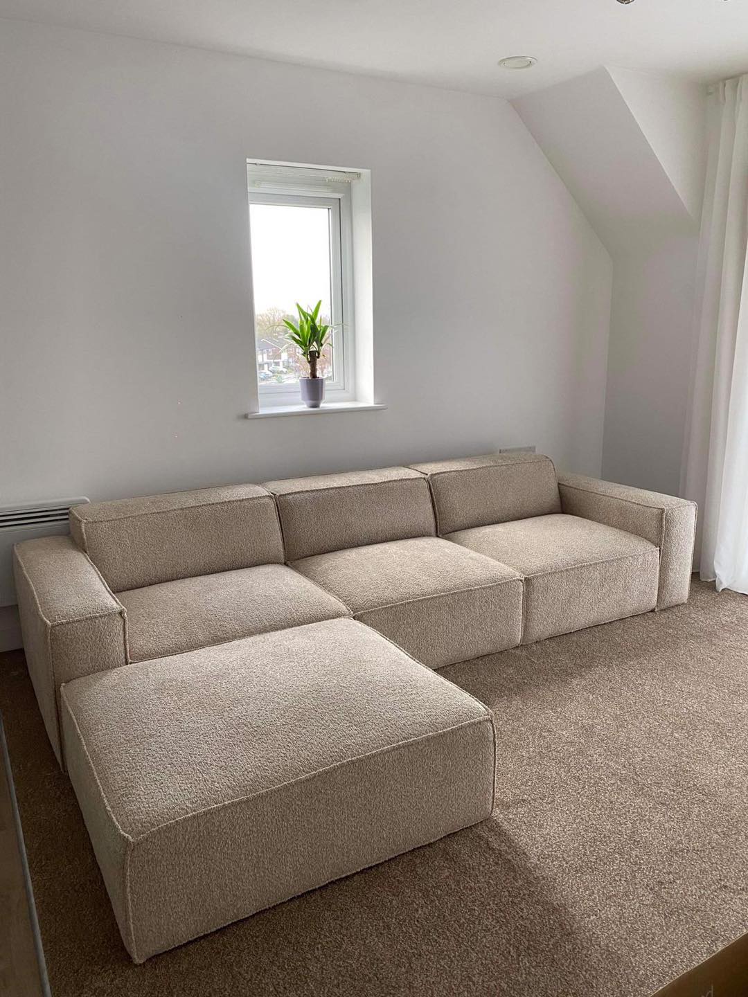 Ivory modular cinema sofa with removable footstool in bright carpeted living room