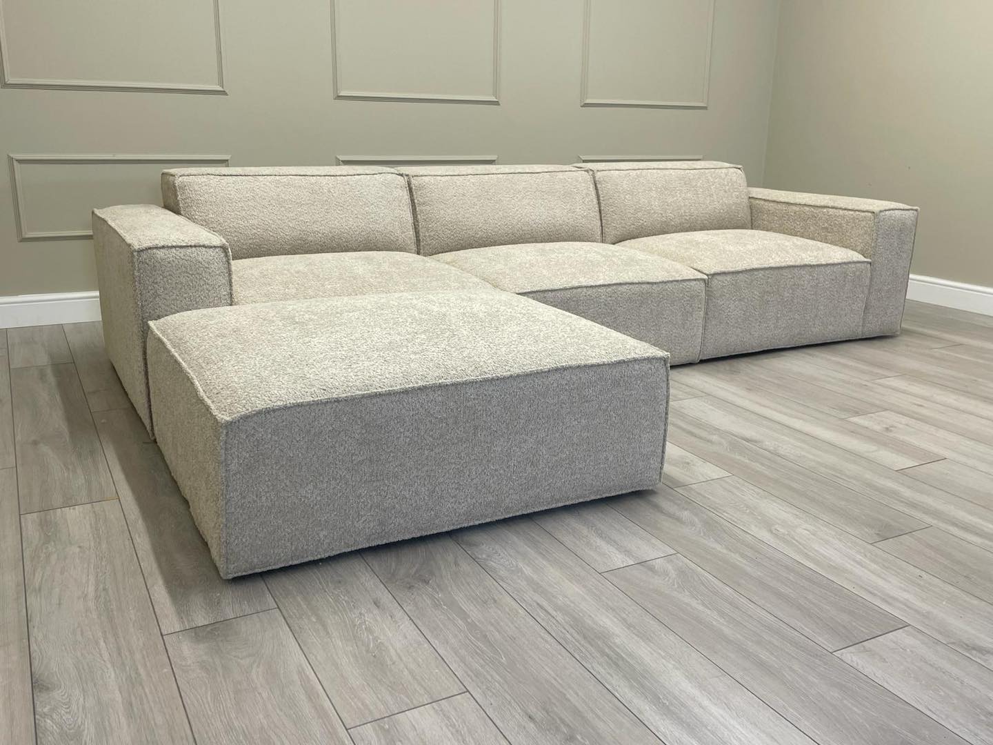 Ivory modular cinema sofa with removable footstool on grey wood floor in modern room