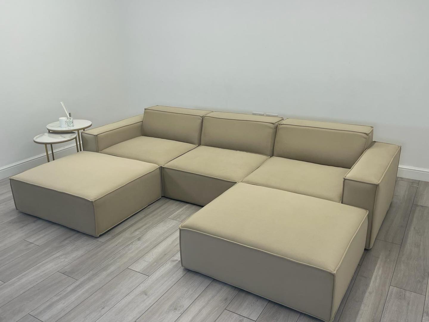 Ivory modular cinema sofa with removable footstool in modern living room, light wood floor