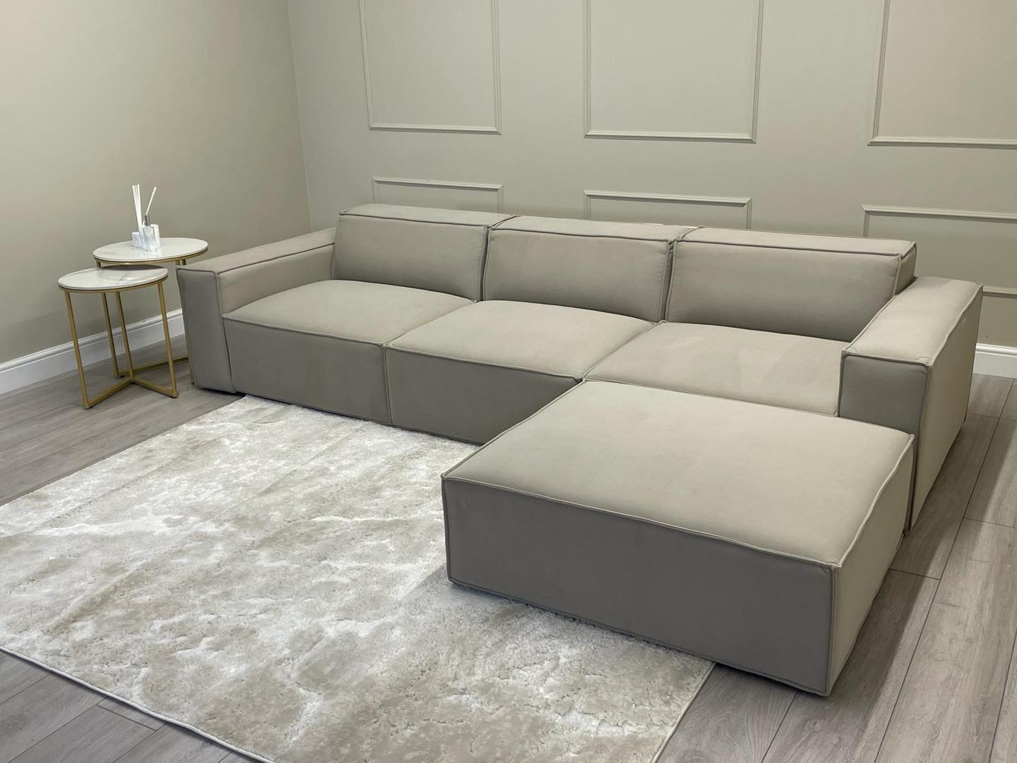 Ivory corner cinema sofa with removable footstool on a light rug and modern accent tables