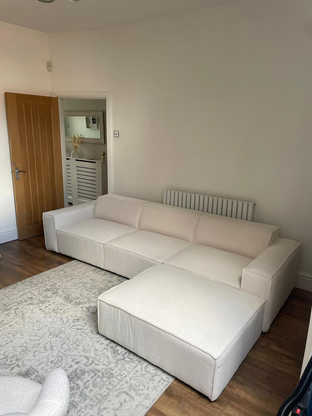 Ivory modular sofa with removable footstool in modern living room on patterned rug
