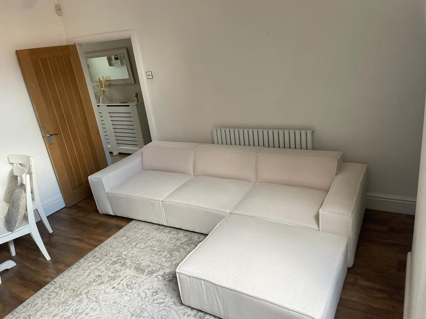 Ivory L-shaped cinema sofa with removable footstool in modern living room