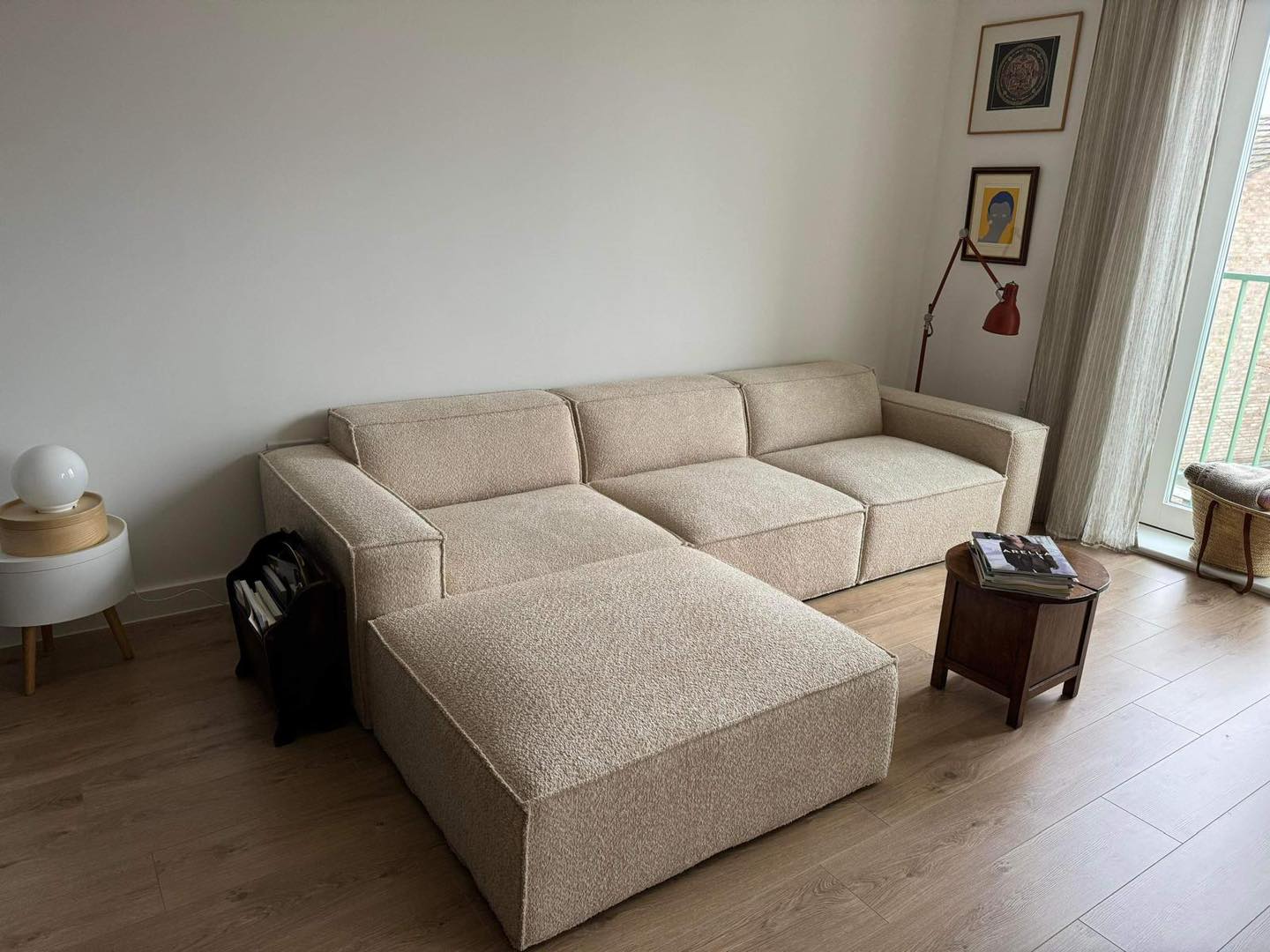 Modern ivory sectional sofa with removable footstool in bright living room with wooden floor