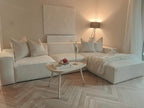 Ivory corner cinema sofa with removable footstool in modern living room, styled with white pillows and cozy throw blanket.