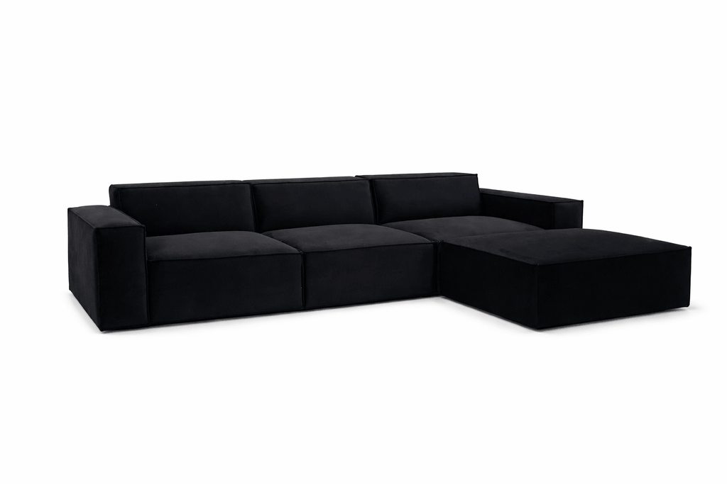 Black modular cinema sofa with wide arms and a matching removable footstool on white background