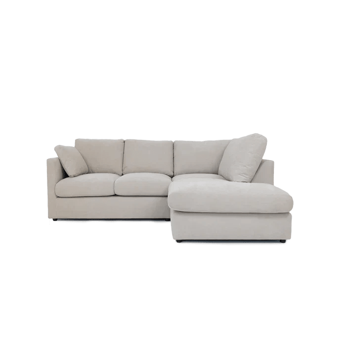 Modern cream right corner sofa with plush cushions and chaise lounge, isolated on white background