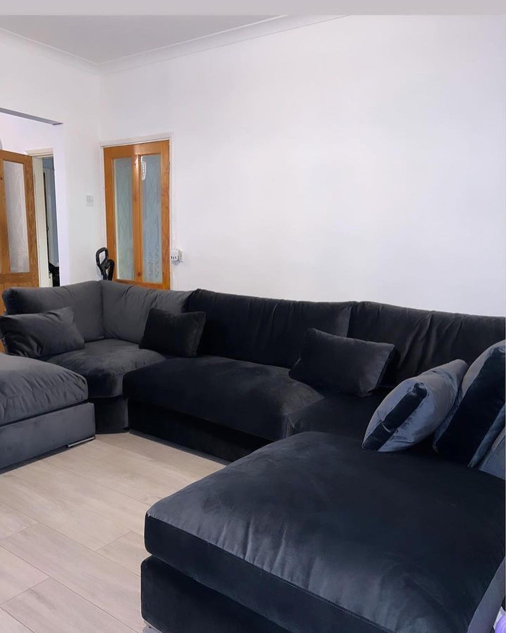 Large U-shaped silver velvet sofa with full back and plush cushions in a modern living room