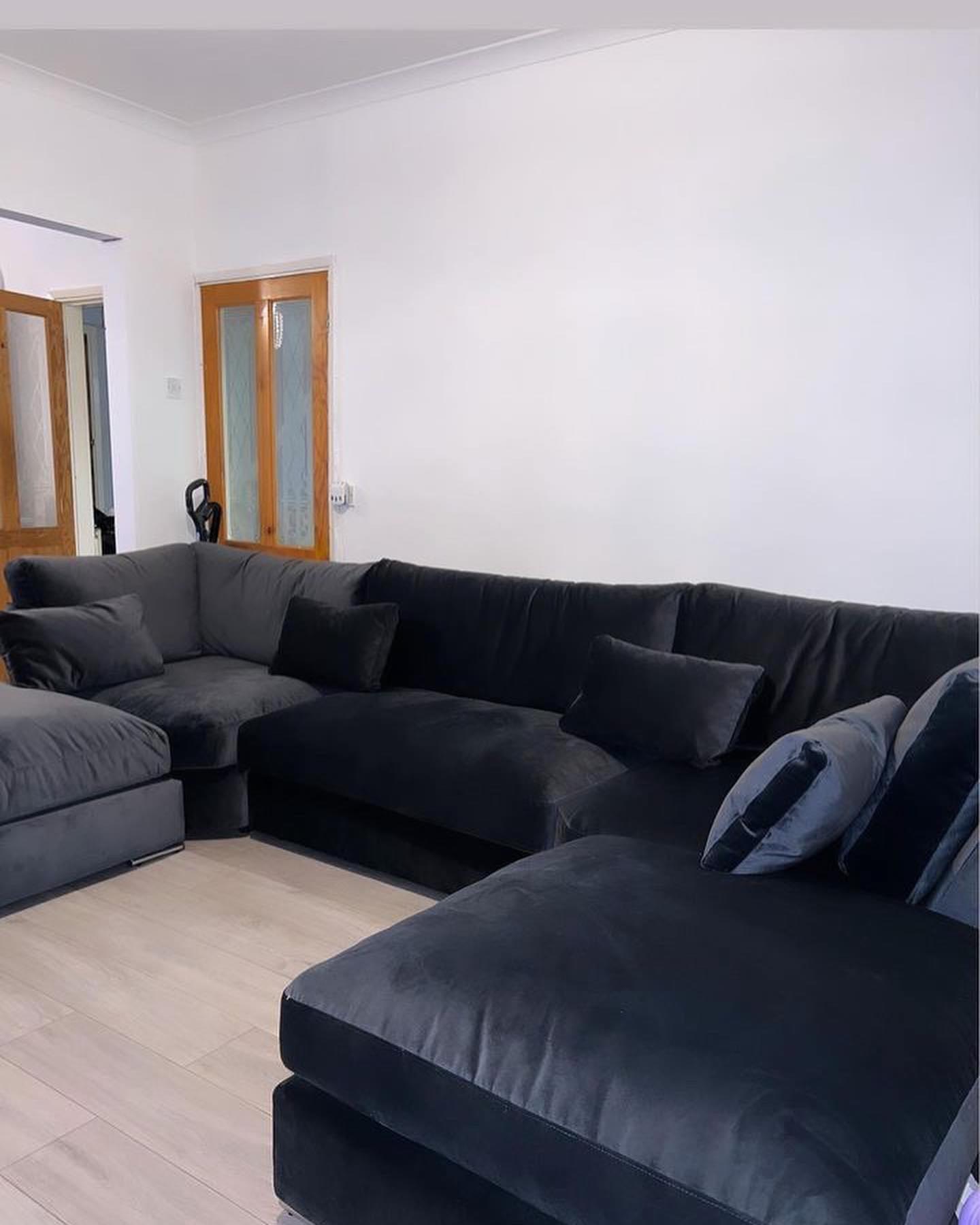 Large U-shaped silver velvet sofa with full back and plush cushions in a modern living room