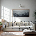 Modern living room with a large cream sofa, neutral cushions, and minimal decor