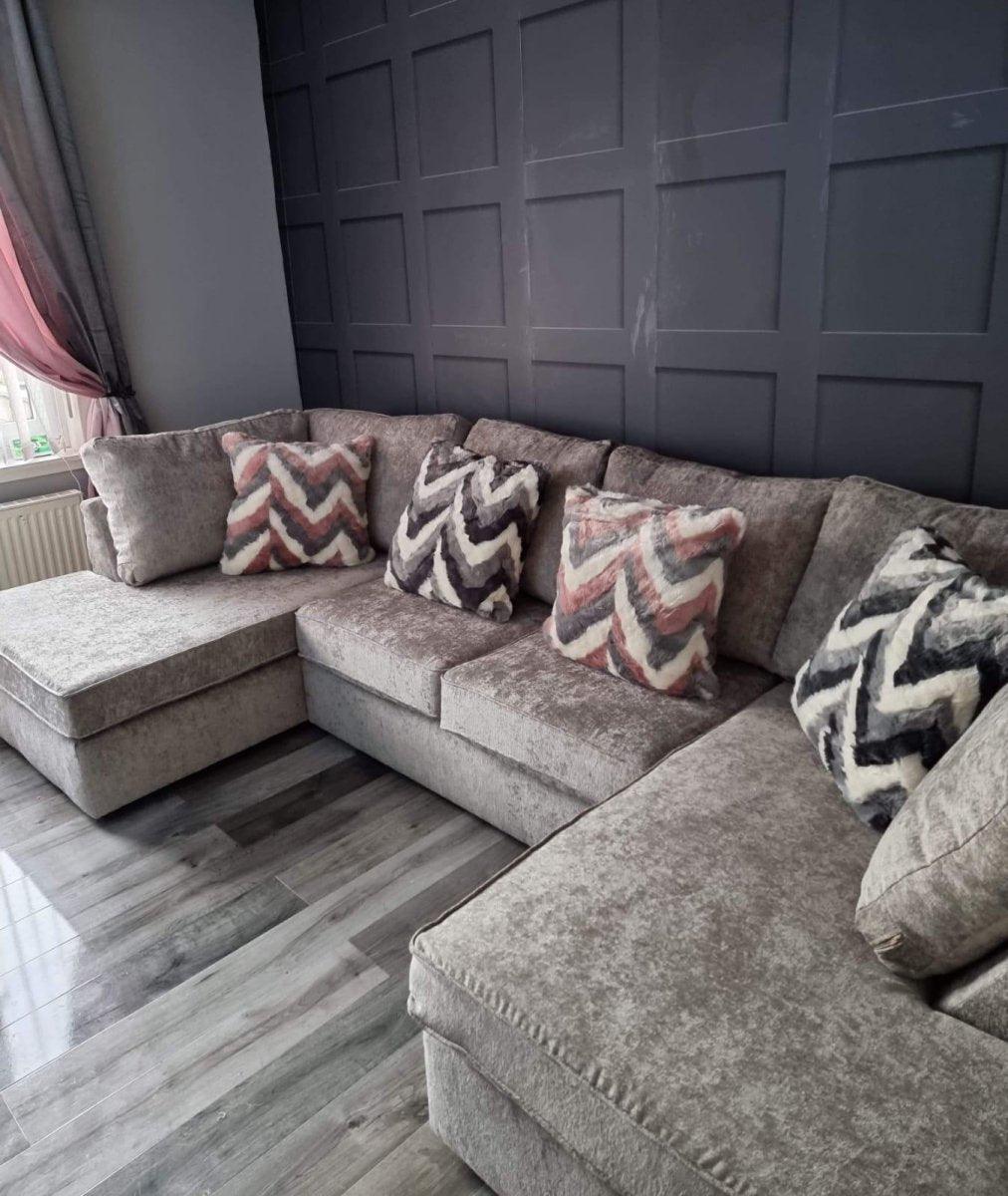 Large U-shaped grey sectional sofa with textured fabric and patterned cushions in a modern living room.