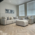Modern living room with beige 3-seater sofa, armchair, and footstool set, herringbone floor