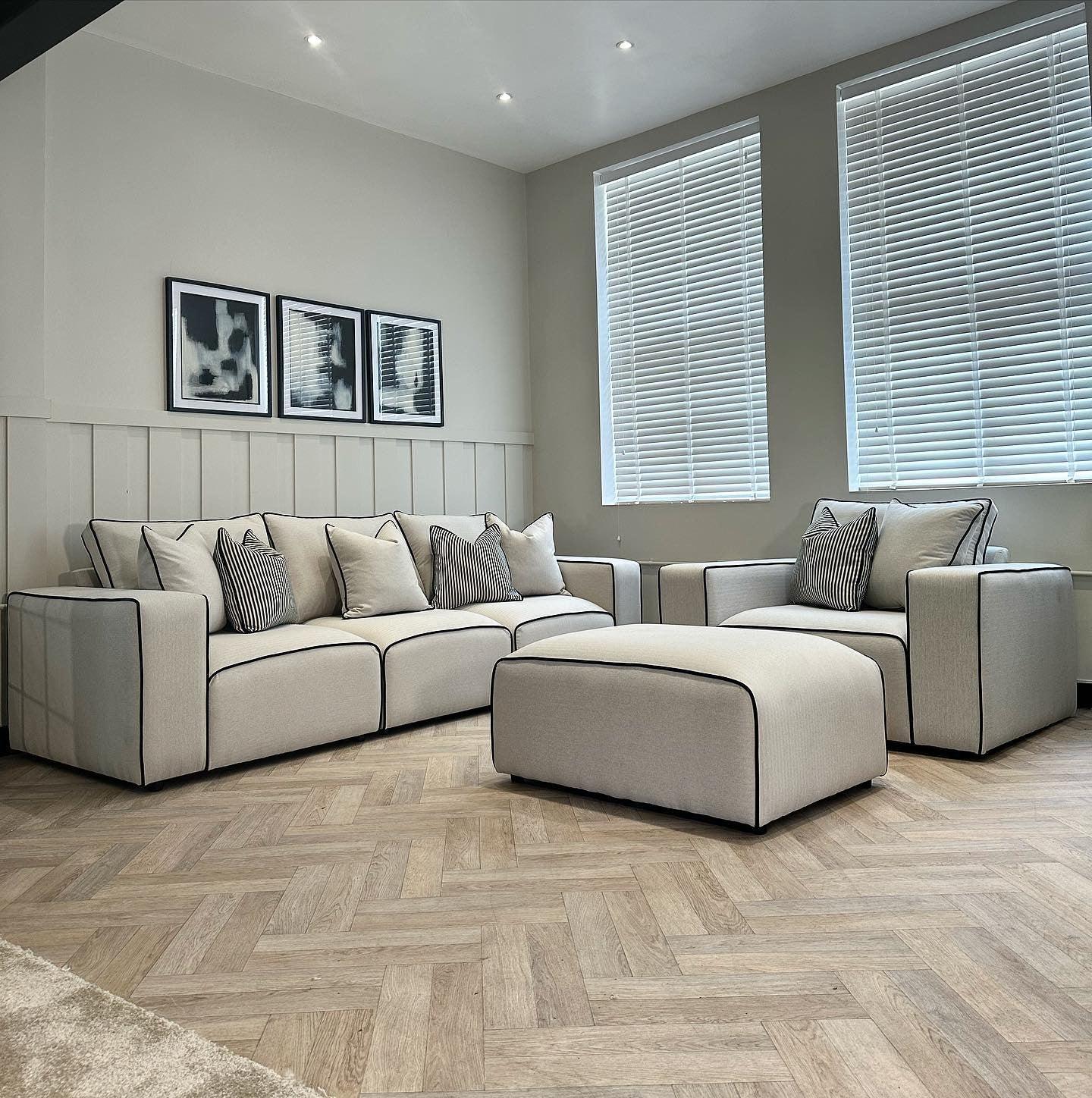 Modern living room with beige 3-seater sofa, armchair, and footstool set, herringbone floor