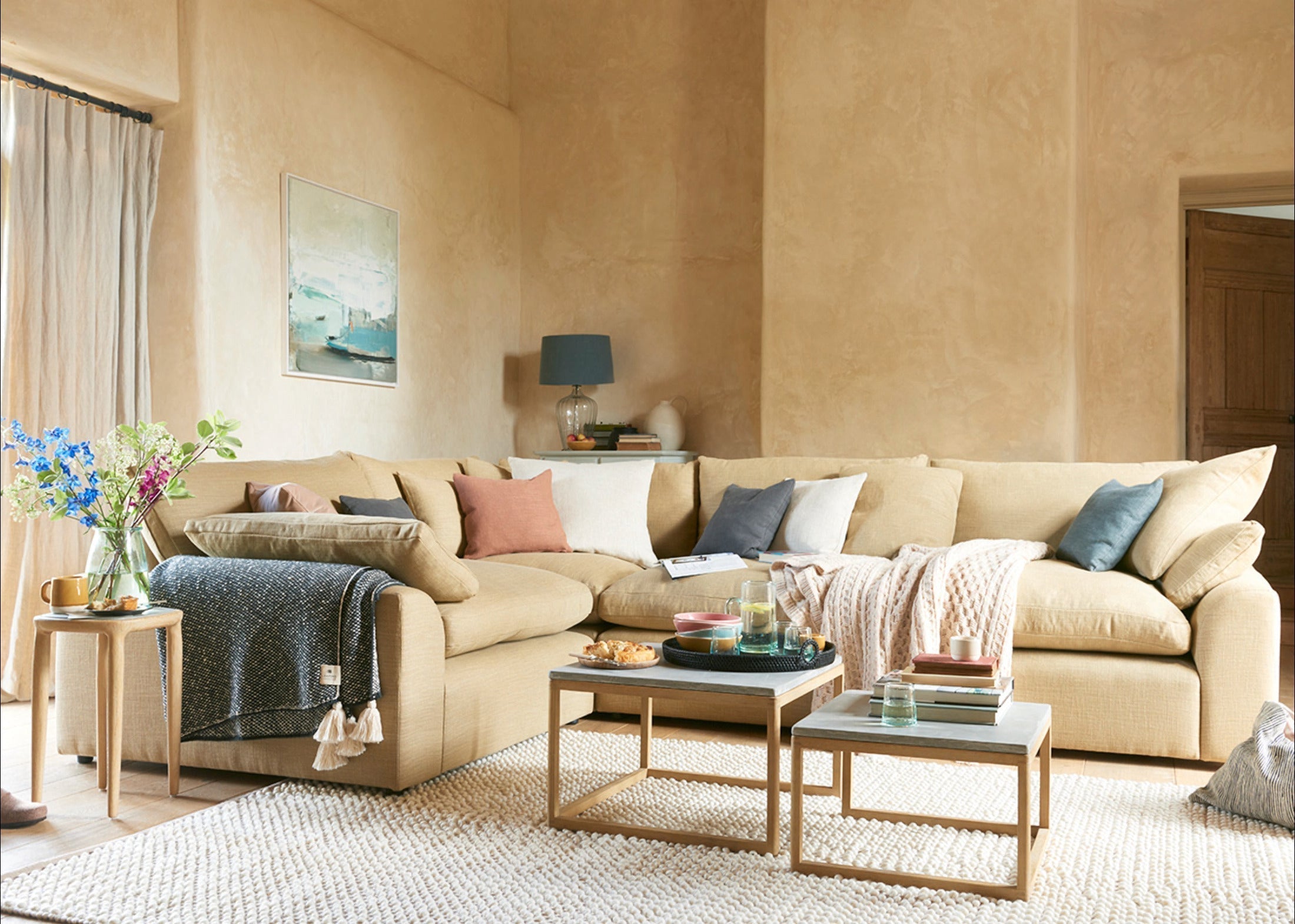 Modern yellow modular corner sofa with assorted cushions in a cozy neutral living room