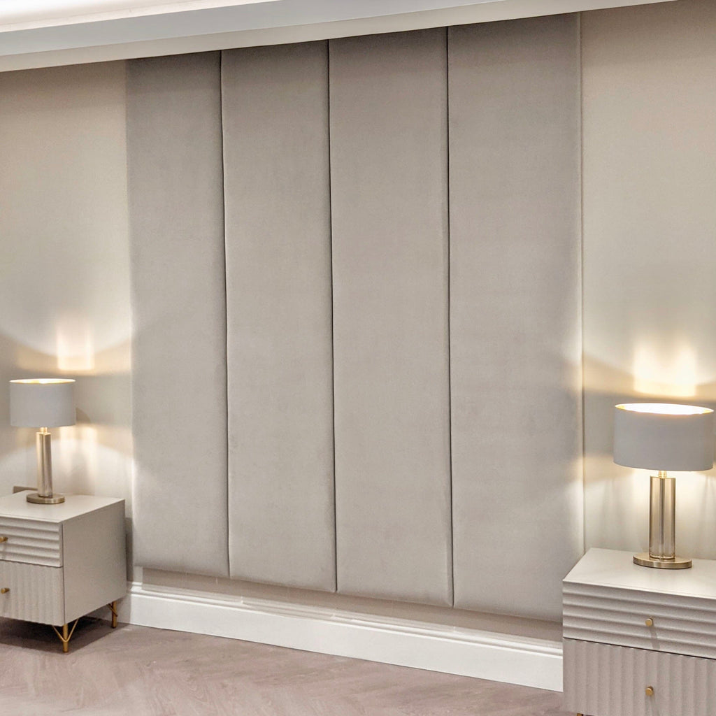 Cream velvet upholstered headboard wall panels with modern bedside tables and lamps