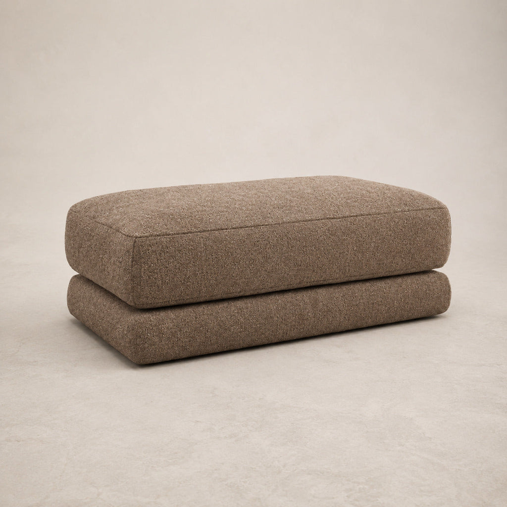 Aurelia Large Footstool in Coffee on a clean stone studio background