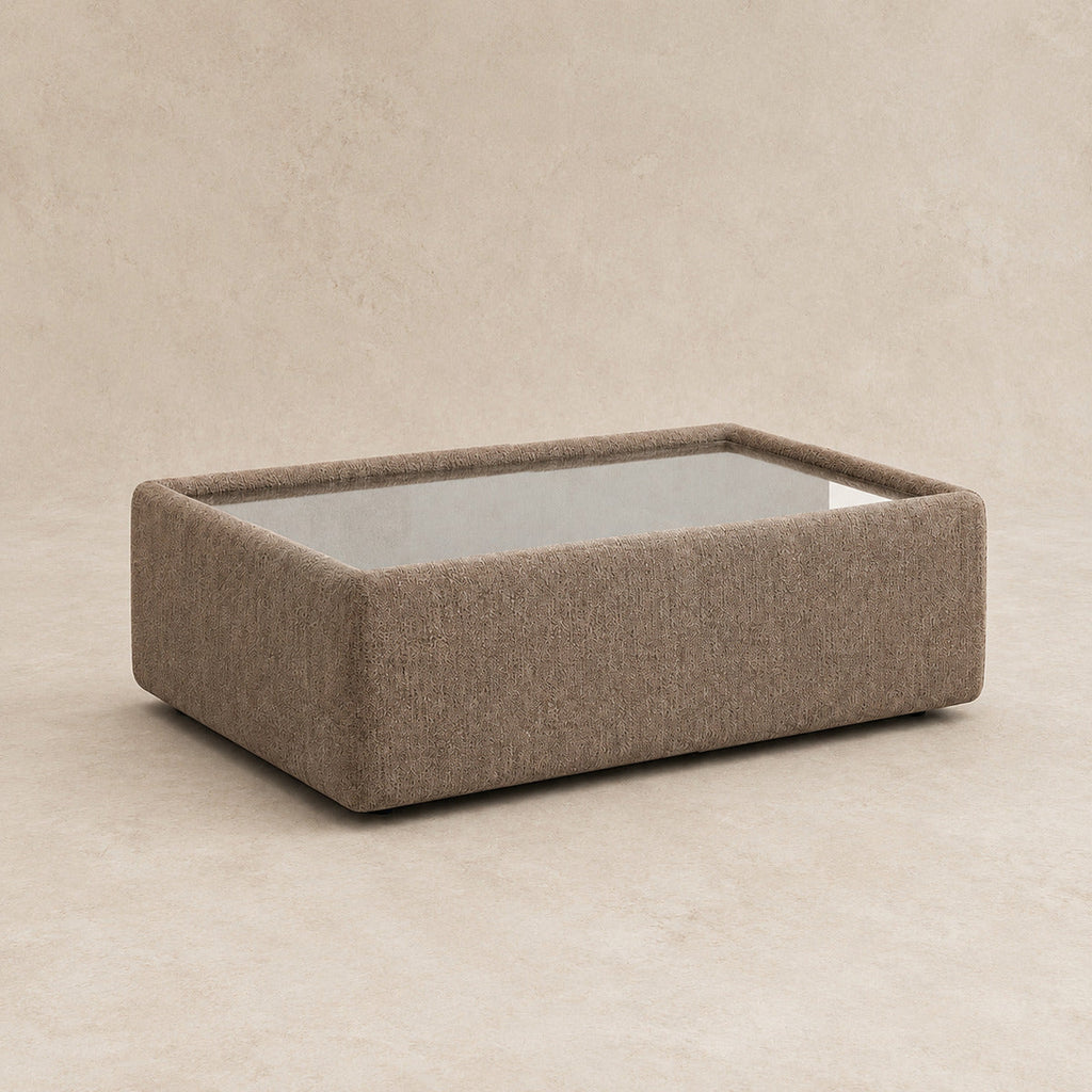 Aurelia Upholstered Rectangle Glass-Top Table in Coffee on a clean stone studio background