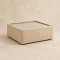 Aurelia Upholstered Square Glass-Top Table in Summer Beach on a clean stone studio background