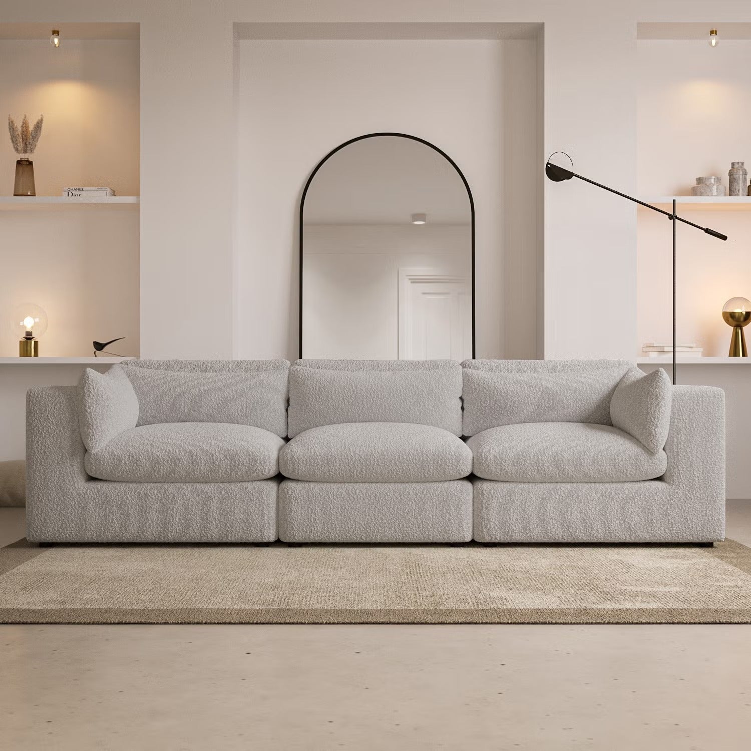 Luxury white bouclé sofa in modern living room with arched mirror and ambient lighting