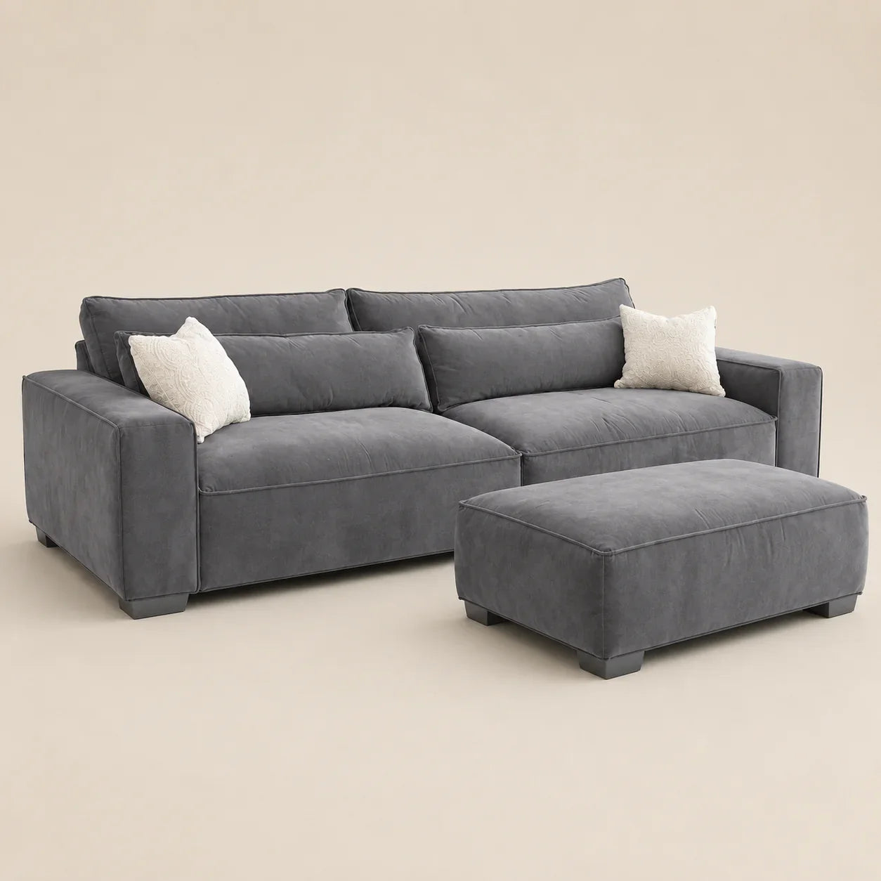 Grey velvet sectional sofa with matching ottoman and white throw pillows, modern luxury living room furniture