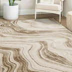 Beige and brown abstract wave pattern area rug in modern living room with white armchair