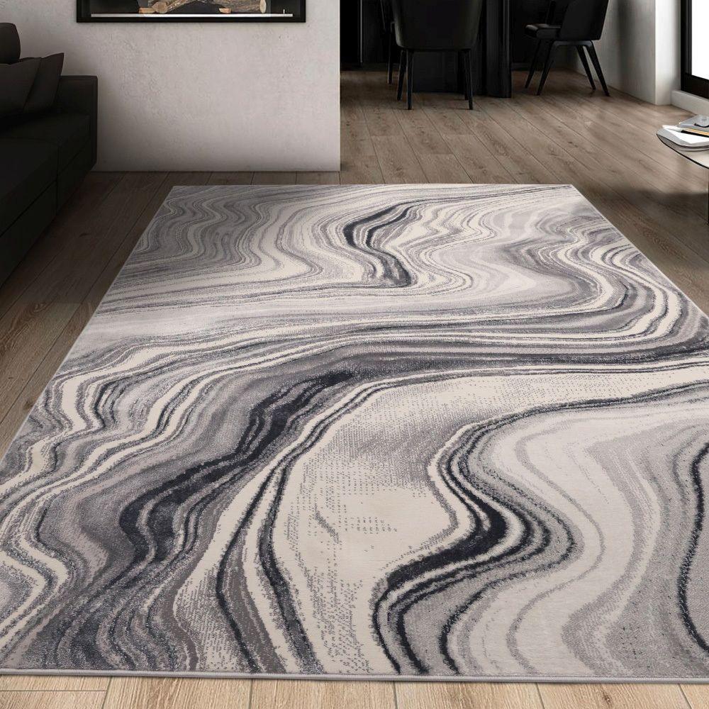 Gray and white abstract wave pattern area rug in modern living room with wooden floors