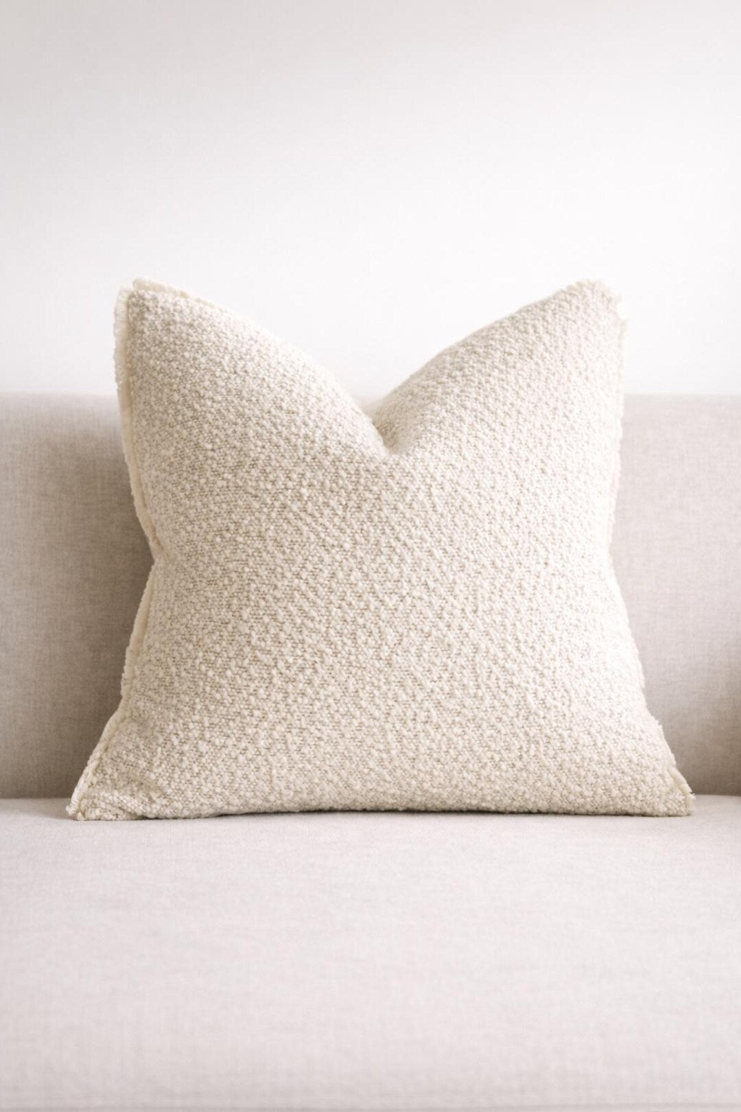 Cream textured throw pillow on neutral sofa, luxury home decor accent