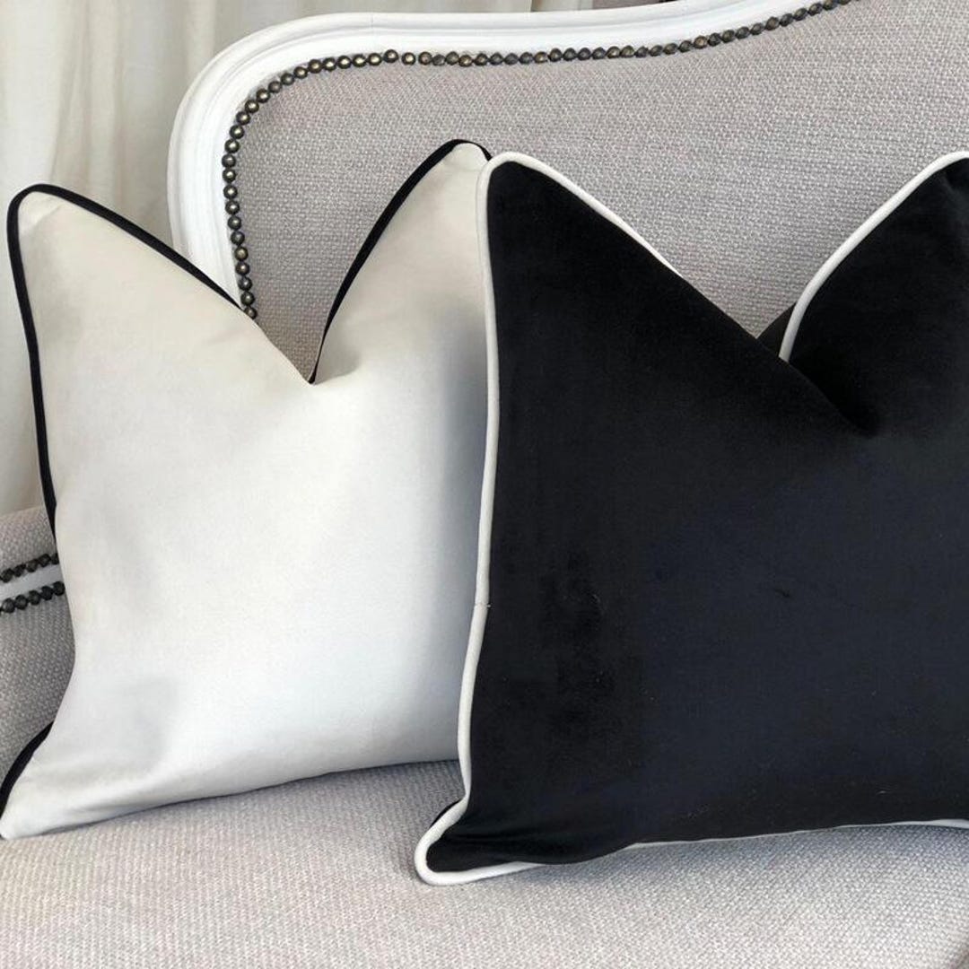 Luxury black and white velvet throw pillows on a grey sofa with nailhead trim